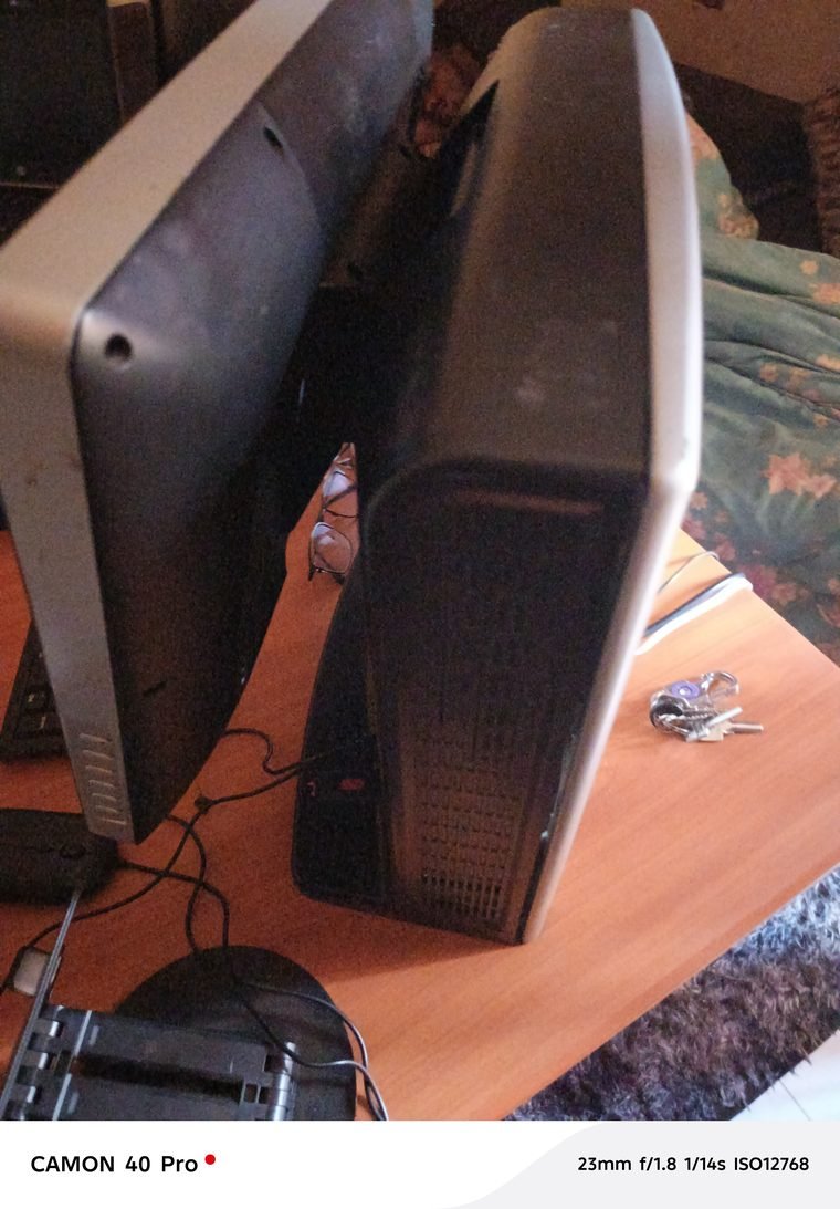 Two desktop computer monitors on a wooden desk with a keyboard, mouse and cables, photographed in April 2026