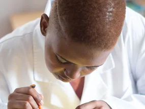 Black electronics technician testing a circuit board