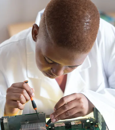 Black electronics technician testing a circuit board