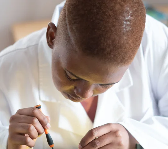 Black electronics technician testing a circuit board