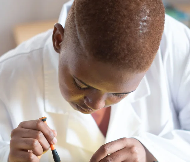 Black electronics technician testing a circuit board