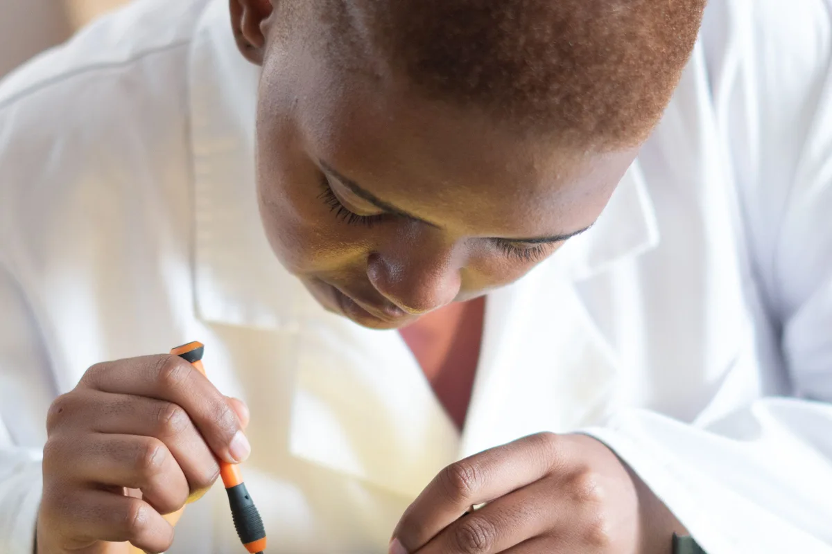 Black electronics technician testing a circuit board