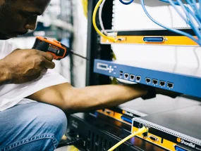 Black technician servicing hardware in a data centre