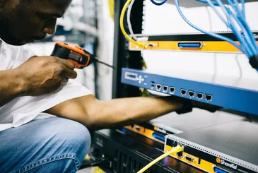 Black technician servicing hardware in a data centre