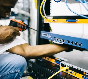 Black technician servicing hardware in a data centre