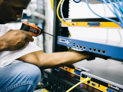 Black technician servicing hardware in a data centre