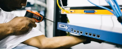 Black technician servicing hardware in a data centre
