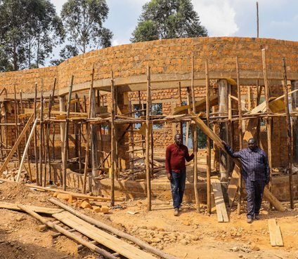 Workers inspecting a brick building under construction