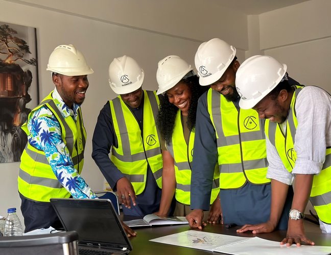African engineers in safety equipment reviewing plans