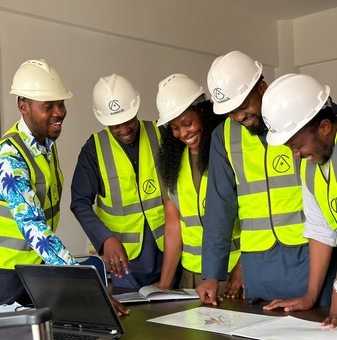 African engineers in safety equipment reviewing plans