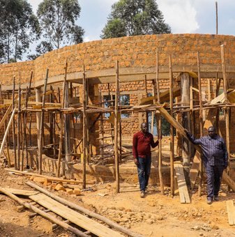 Workers inspecting a brick building under construction