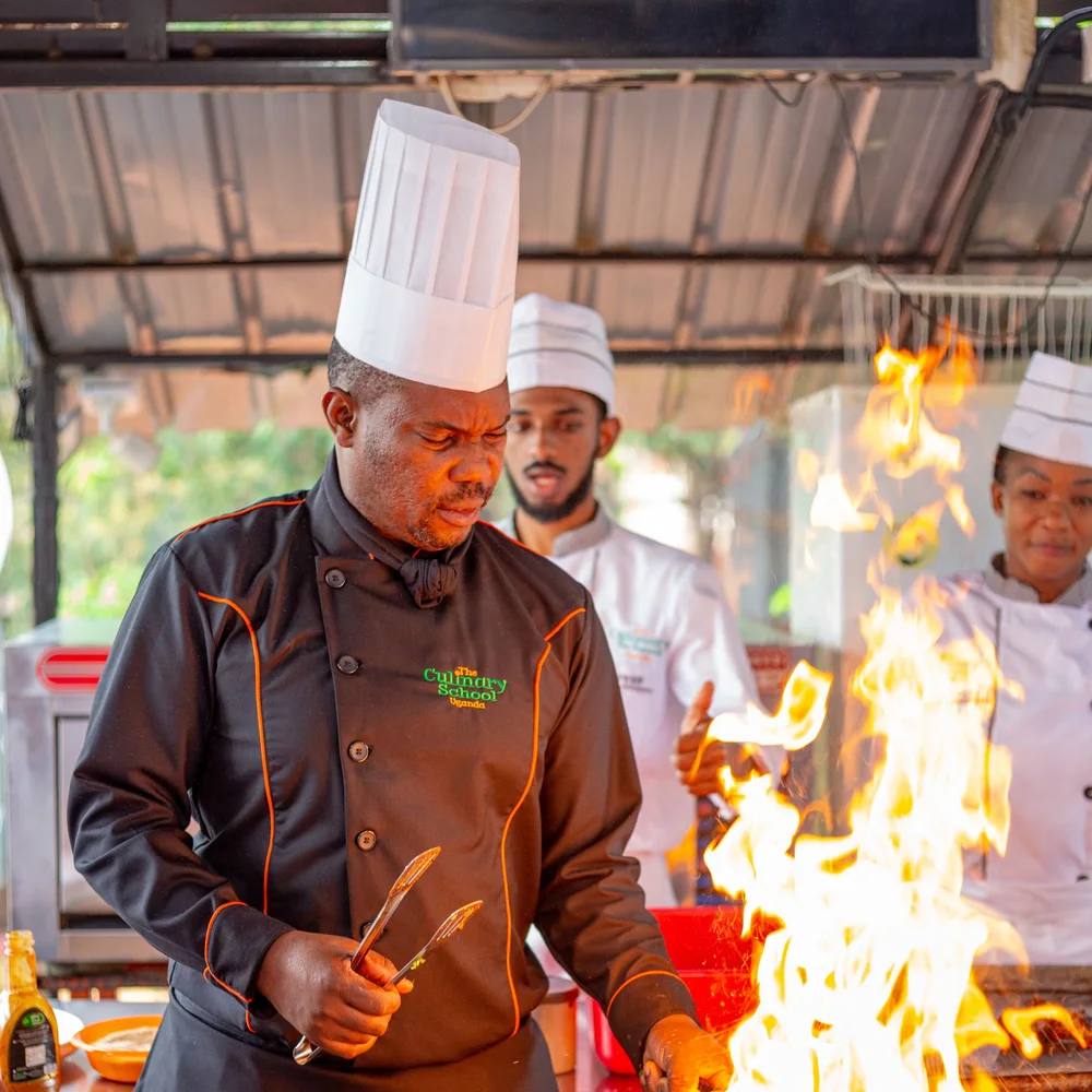 Chefs demonstrating cooking with fire in Uganda