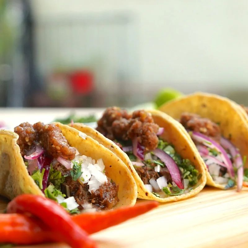 Beef tacos served on a wooden tray