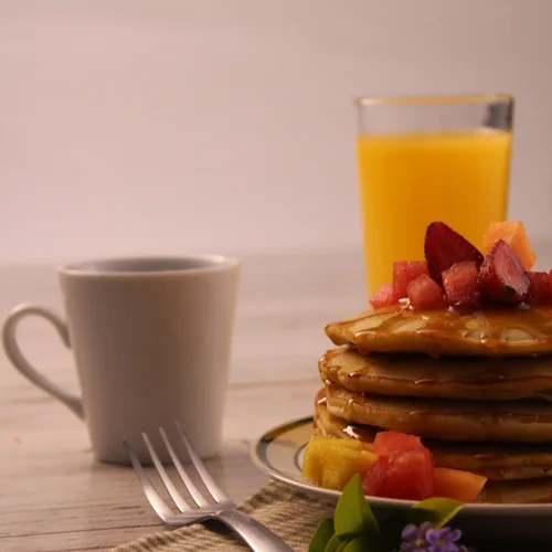Pancakes with fruit, coffee and orange juice