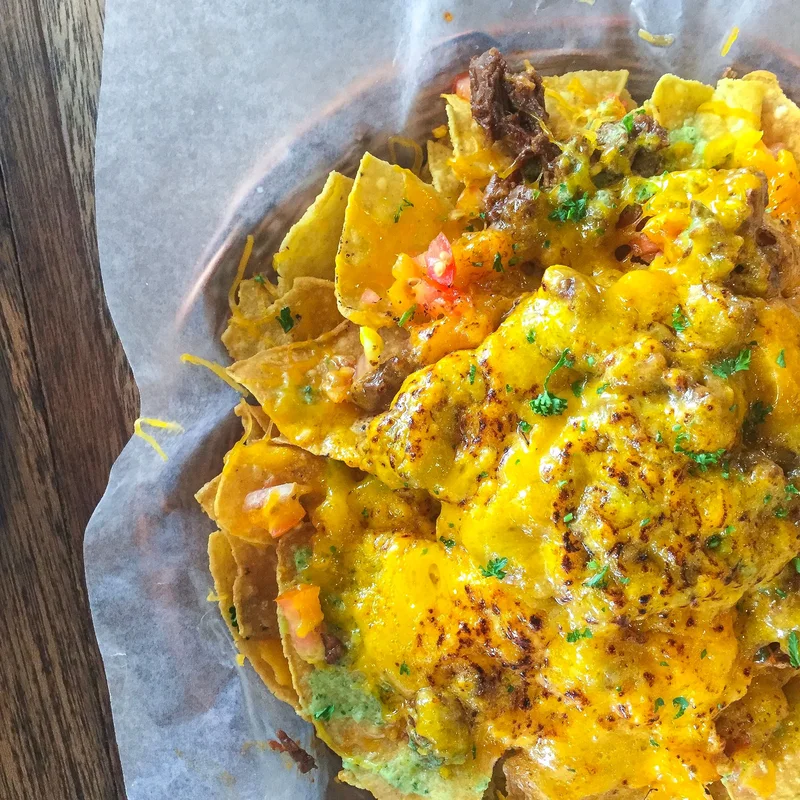 Nachos topped with cheese and vegetables