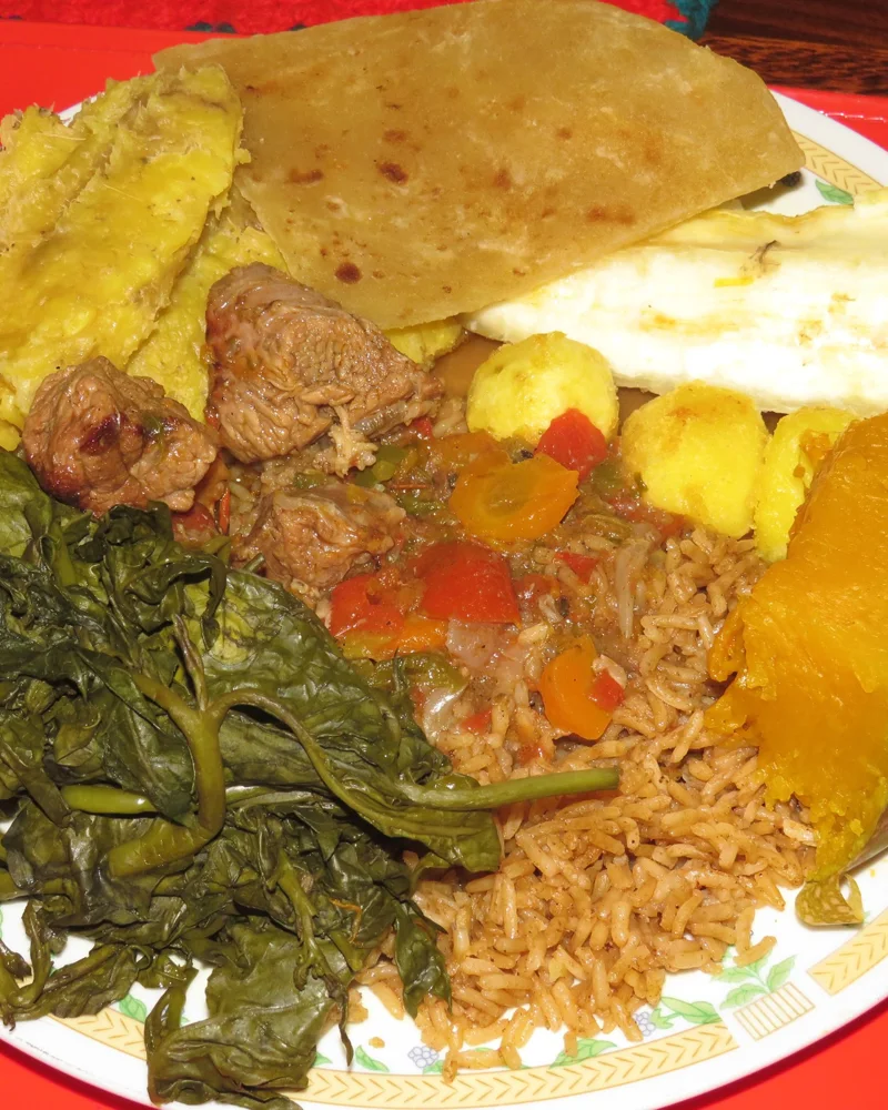 A Ugandan meal with matooke, pilau, cassava, chapati, vegetables and beef stew