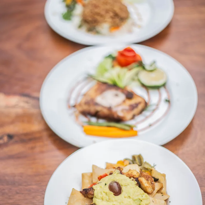 Three colourful plated dishes photographed in Uganda
