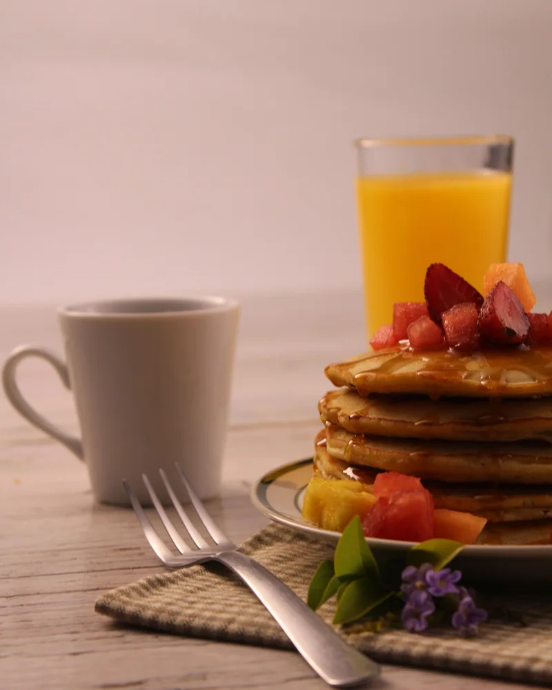Pancakes with fruit, coffee and orange juice