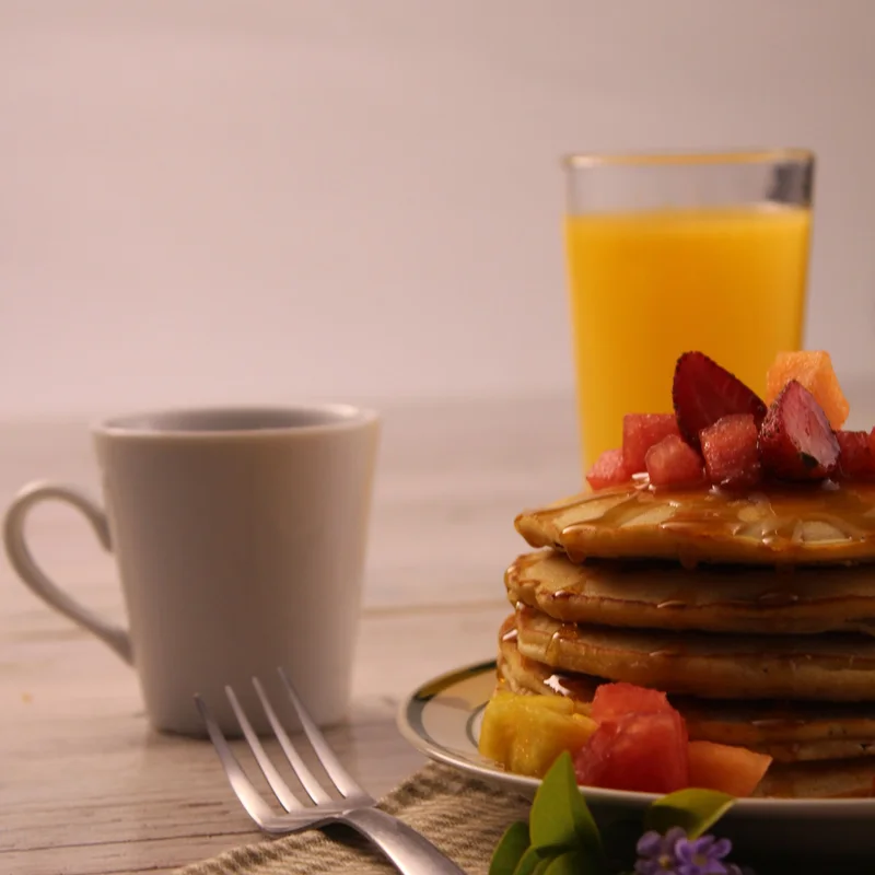 Pancakes with fruit, coffee and orange juice