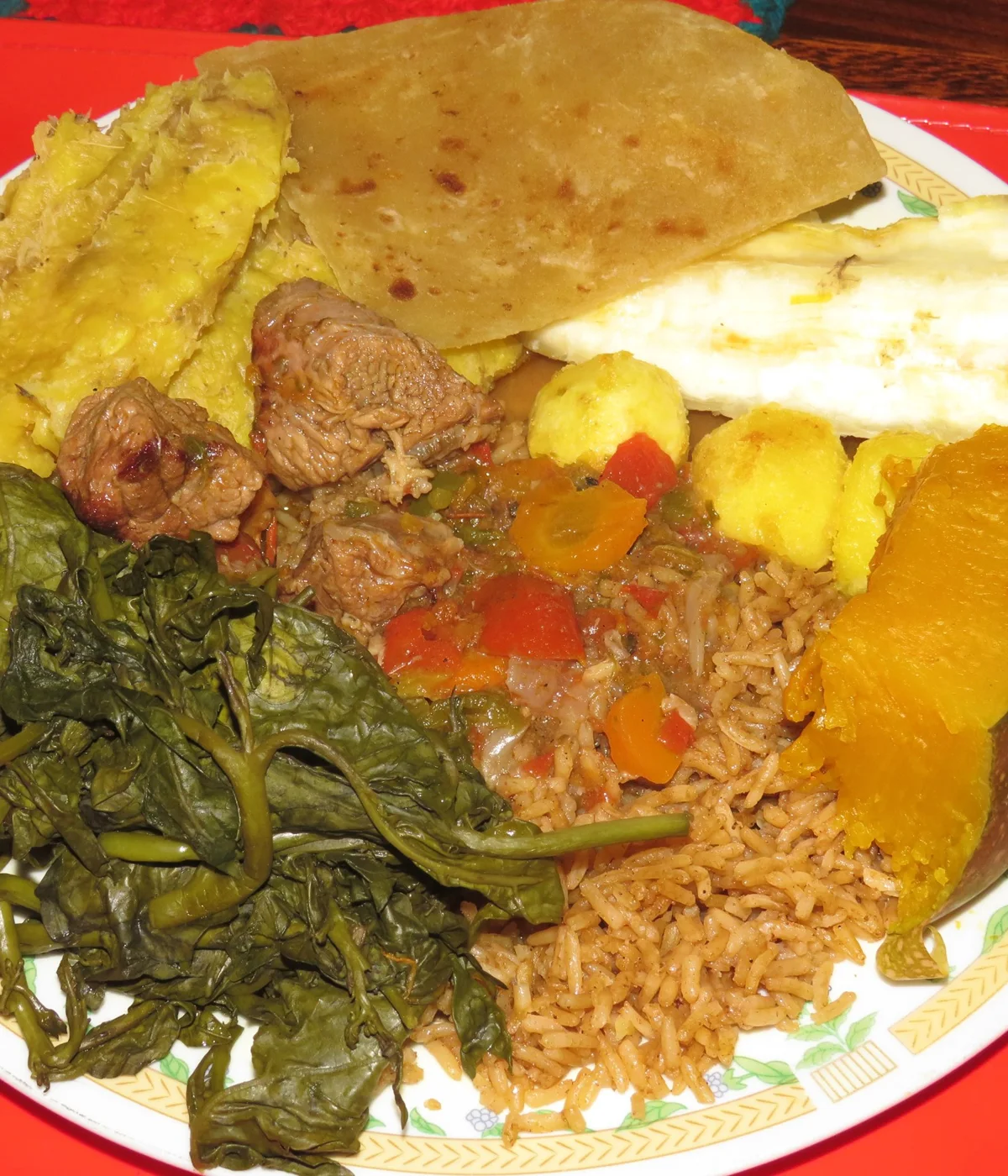A Ugandan meal with matooke, pilau, cassava, chapati, vegetables and beef stew