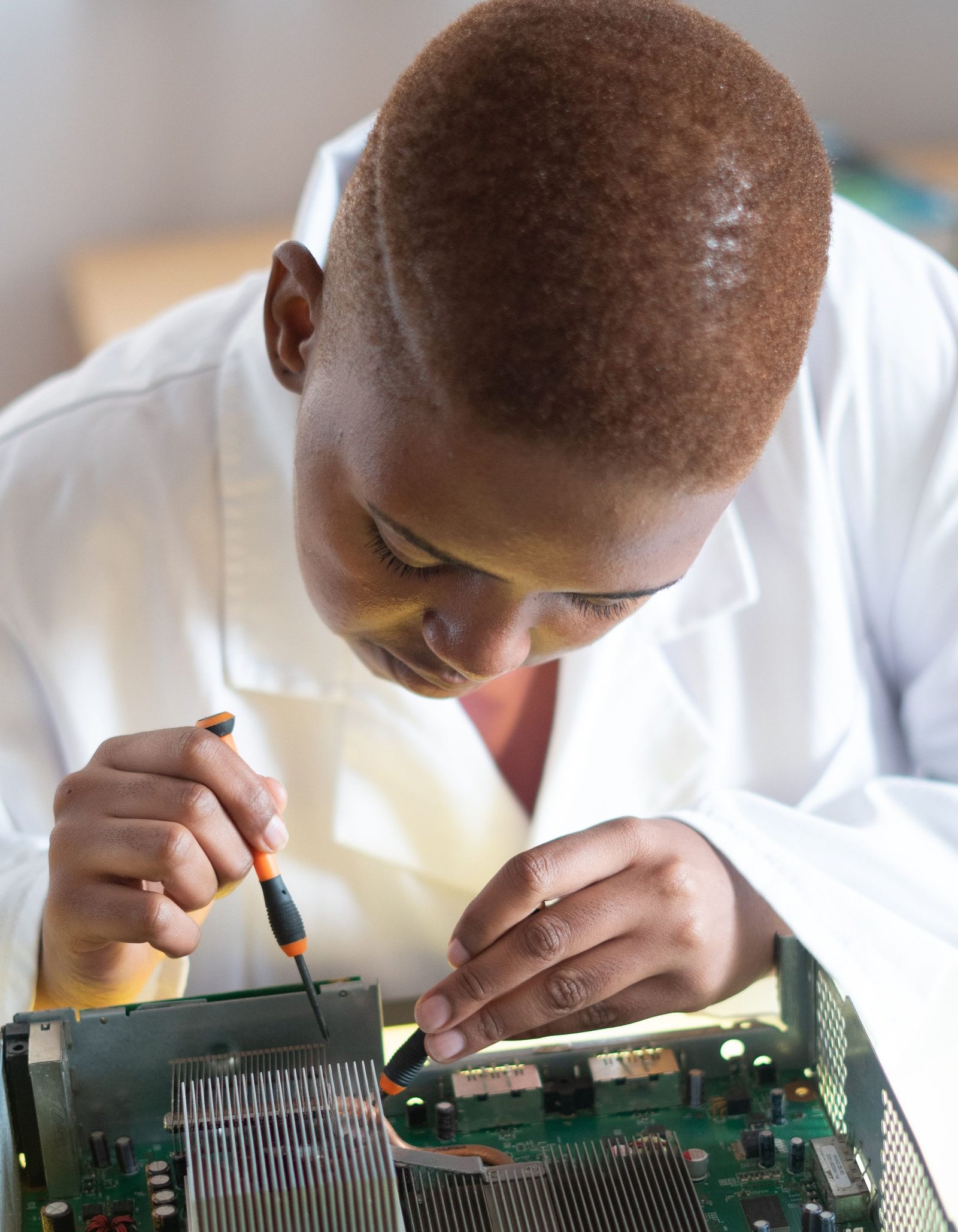 Black electronics technician testing a circuit board