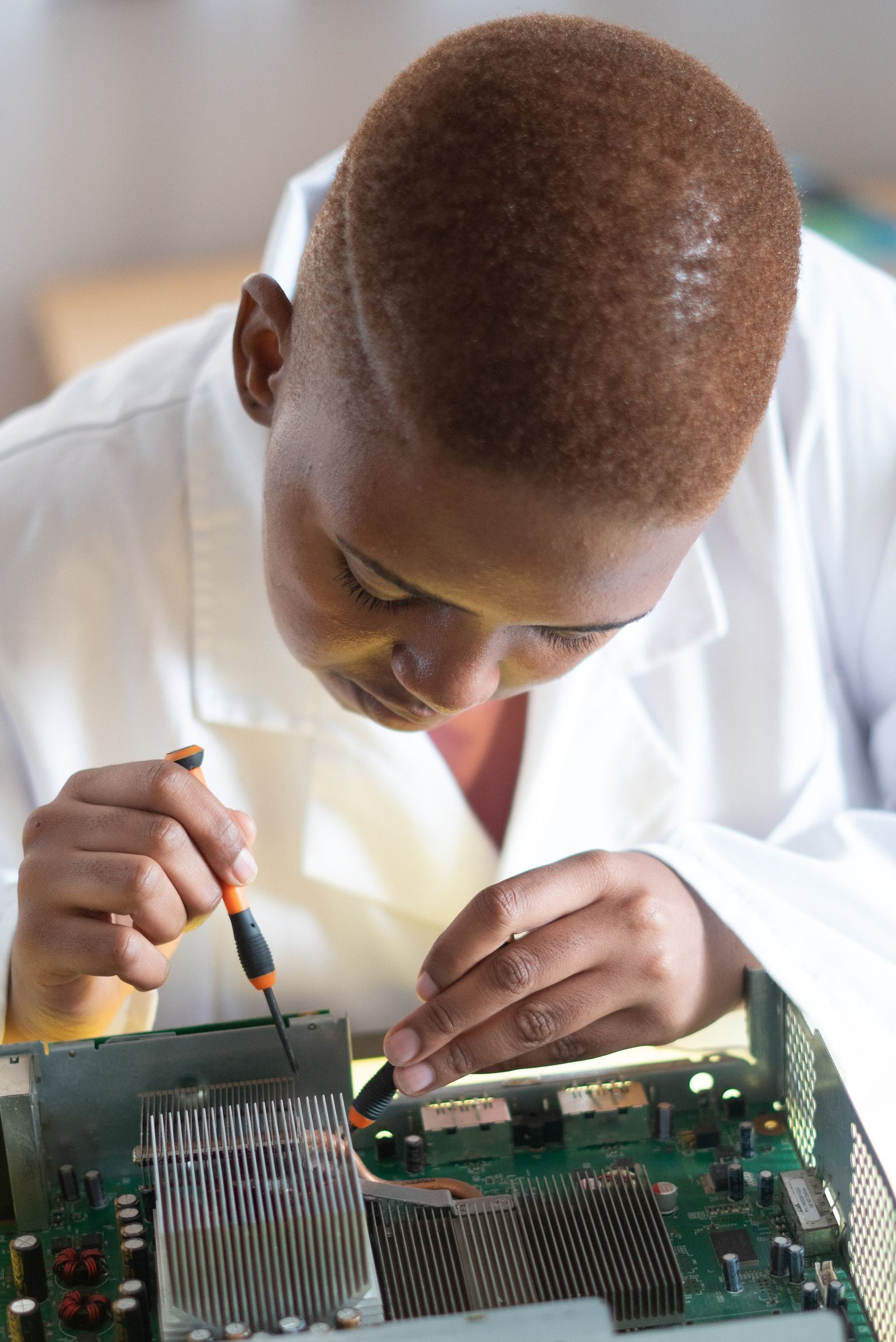 Black electronics technician testing a circuit board