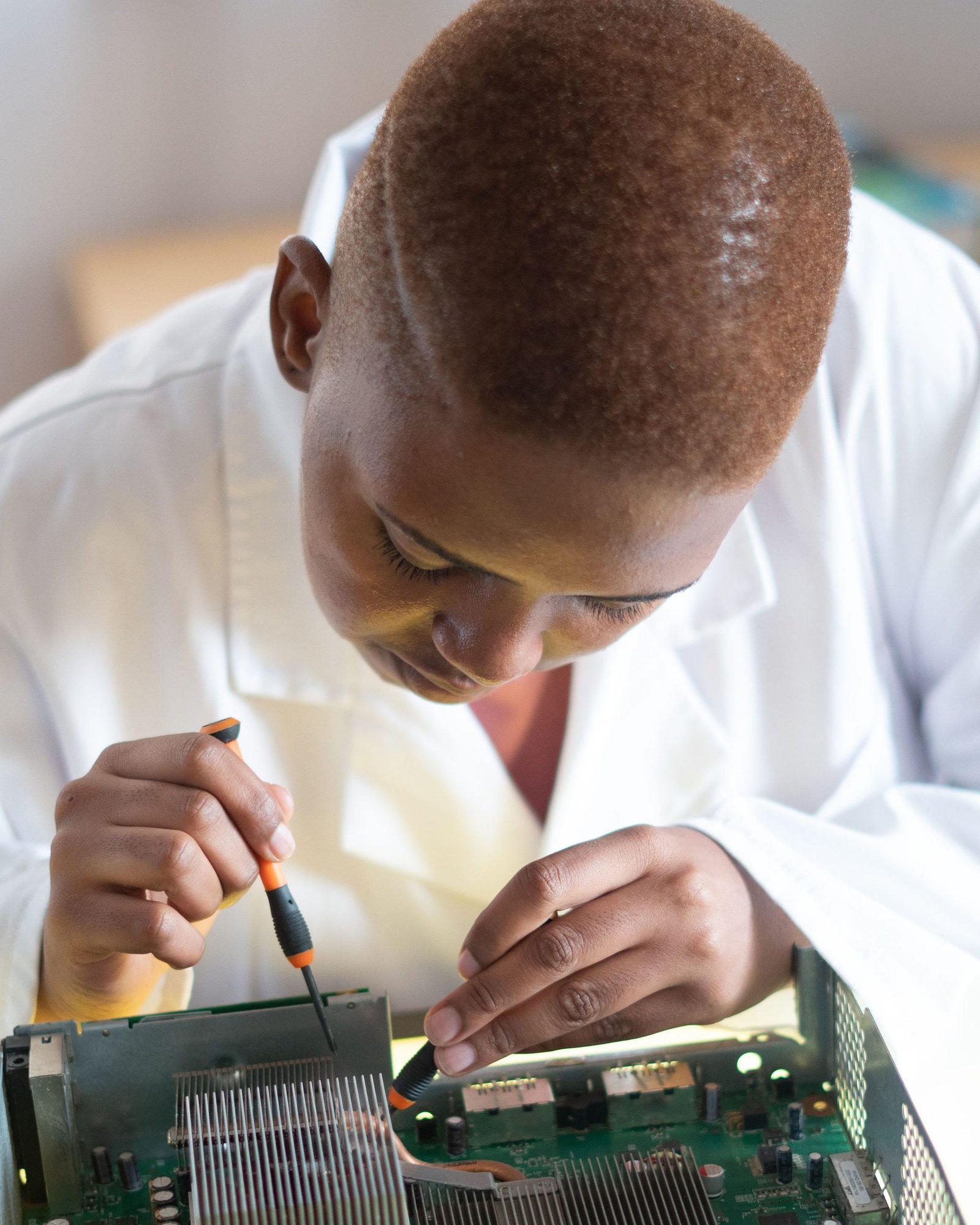 Black electronics technician testing a circuit board