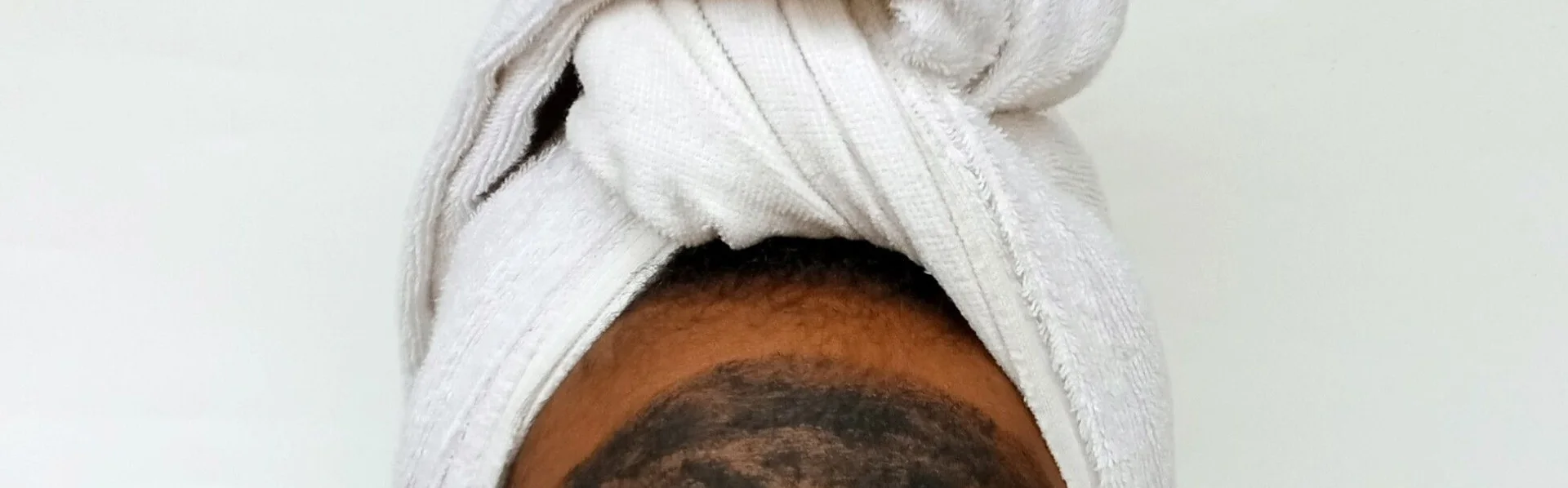 Black woman applying a clay skincare mask