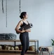 Black woman holding a yoga mat in a studio