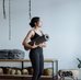 Black woman holding a yoga mat in a studio