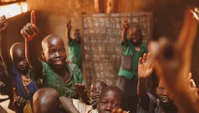 Pupils raising their hands in a Kitgum classroom