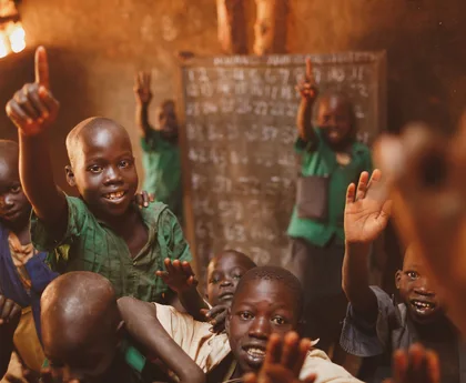 Pupils raising their hands in a Kitgum classroom